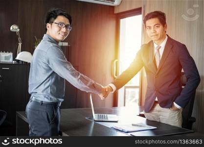 Asian Business people shaking hands and smiling their agreement to sign contract and finishing up a meeting