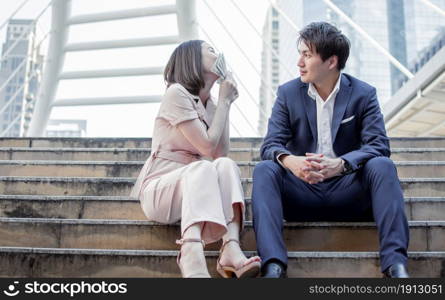 Asian business woman kissing banknotes after her boyfriend surprising her by a lot of money.