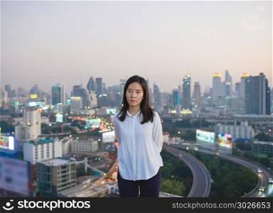 Asian business woman looking at Bangkok city at sunset on roofto. Asian business woman looking at Bangkok city at sunset on rooftop. Asian business woman looking at Bangkok city at sunset on rooftop