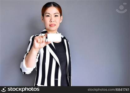 Asian business woman showing business card on gray background with copyspace