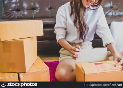 Asian business woman startup small business entrepreneur SME distribution warehouse with parcel mail box. small owner home office. Online marketing and product packaging and delivery service concept