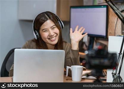 Asian business woman using technology laptop and working from home in home office, freelance and entrepreneur, camera taking video of vlogger or influence Live, social distance and self responsibility