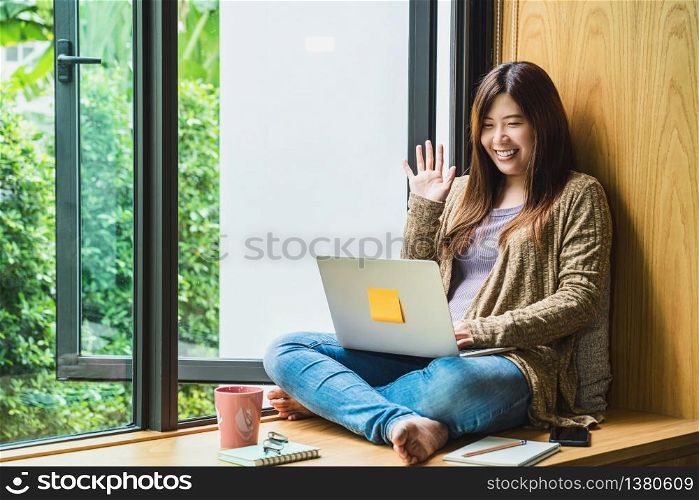 Asian business woman using technology laptop and working from home with say hello or bye, freelance and entrepreneur, creative design and blogger, social distance and self responsibility concept