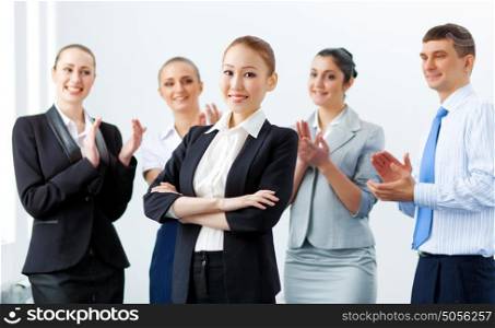 Asian business woman with colleagues. Young asian businesswoman smiling with colleagues applauding joyfully at background