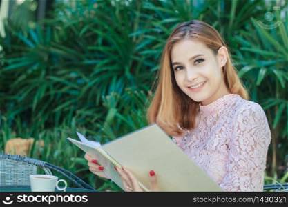 Asian business women smiling working and writing a book and checking document at outdoor ,soft focus