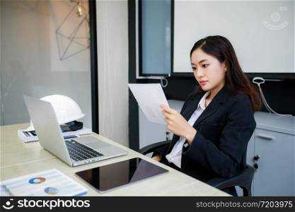 Asian business women using notebook and serious and headache for working