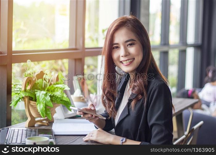 Asian business women using notebook and smart phone and business women smiling happy for working