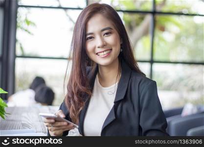 Asian business women using notebook and smart phone and business women smiling happy for working