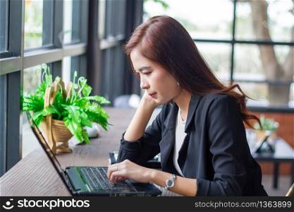 Asian business women using notebook for working and businesswoman serious about the work done until the headache