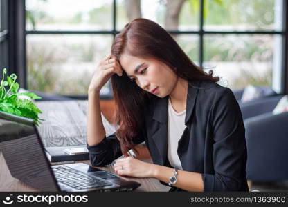 Asian business women using notebook for working and businesswoman serious about the work done until the headache