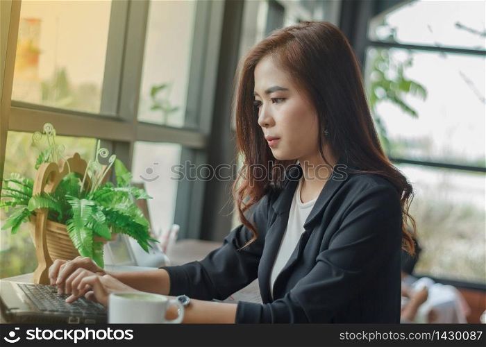 Asian business women using notebook for working ,blurry and soft focus