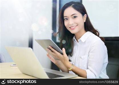 Asian business women using tablet for working at office relax time and smiling
