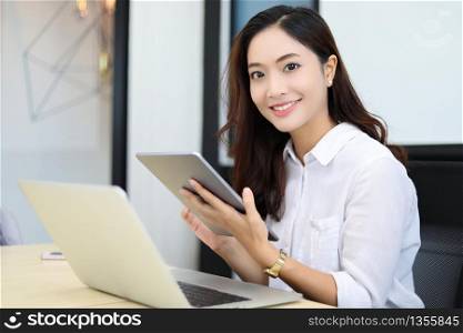 Asian business women using tablet for working at office relax time and smiling
