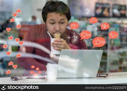 Asian businessman eating noodles with urgent action in rush hour and checking social network application with number of Like, Love, comment, people and fovorite icon, Social media disease concept,