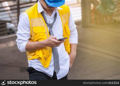 asian businessman engineer standing and use smartphone for chat and sending mail