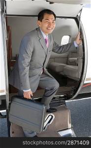Asian businessman getting off airplane.
