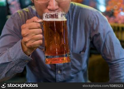 Asian businessman in happiness action and drinking beer after work or sucess job in pub and restaurant, relax and drink concept