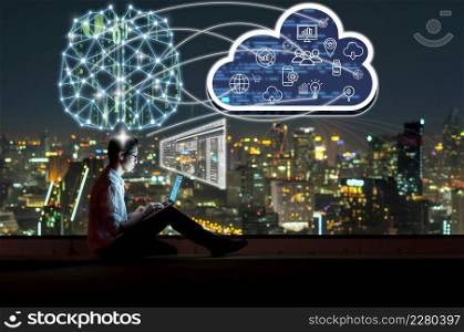 Asian businessman sitting and using the laptop and working with brain and virtual screen connecting with cloud technology over the cityscape background at night time, Business and technology concept