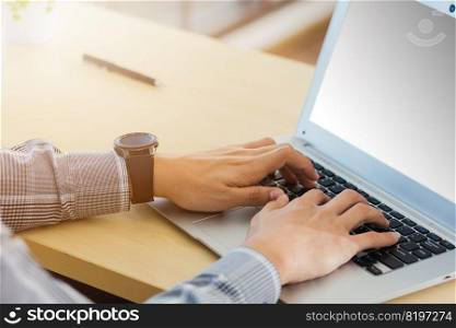 Asian businessman working on his laptop computer with blank copy space screen he typing on keyboard at home office desk. The man play social media on computer table