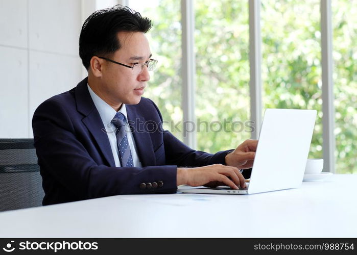 Asian businessman working with laptop computer at office, business concept