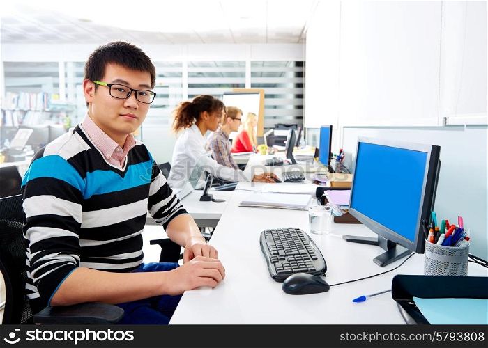 Asian businessman young in multiracial office with computer in a desk row