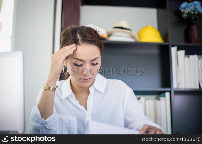 Asian businesswoman and women student serious about the reading book and work hard done until the headache