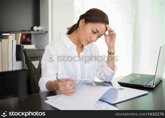 Asian businesswoman and women student serious about the reading book and work hard done until the headache