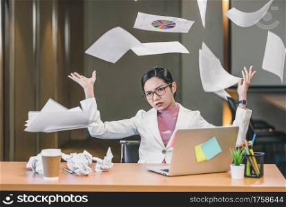 Asian businesswoman angry throwing papers over the herself in office when job fail, unsuccessful project, work hard and Overworked and stressed Concept,