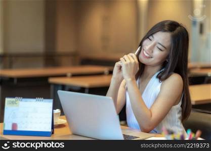 Asian businesswoman in casual suit looking at annual report with happiness action in modern office, business success concept