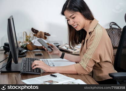 Asian Businesswoman in formal suit writing and working with computer and mobile in office, business and project plan for customer service concept