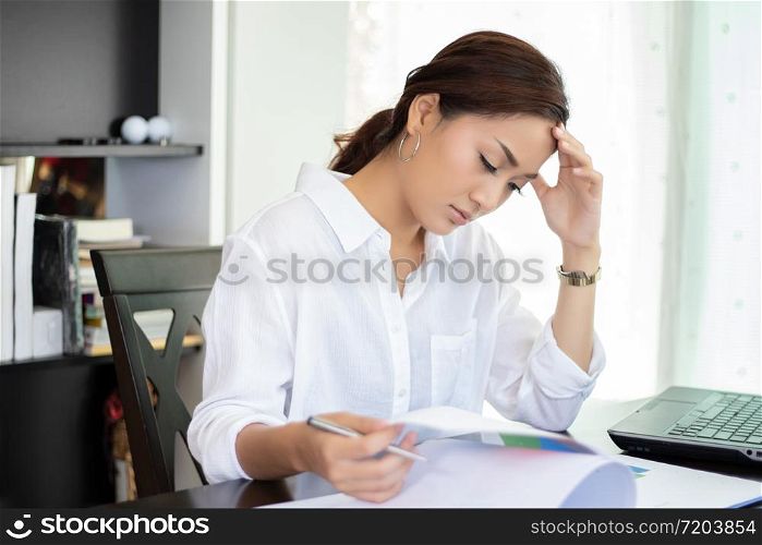 Asian businesswoman serious and headache about the working hard and using notebook