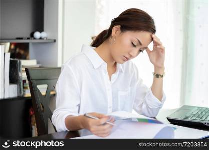 Asian businesswoman serious and headache about the working hard and using notebook