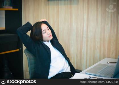Asian businesswoman stretching after work hard in the office