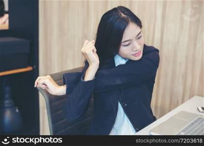 Asian businesswoman stretching after work hard in the office