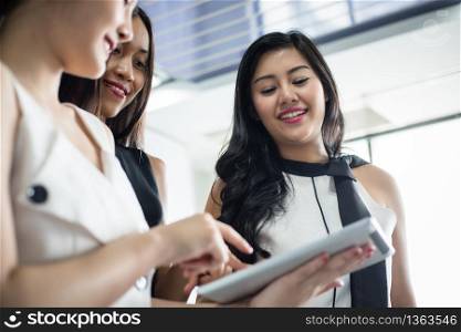 Asian Businesswomen with partner discuss about the detail of work on smartphone and business women smiling