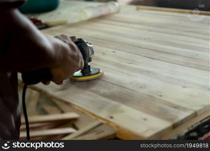 Asian carpenter build furniture or products from slat and timber wood from natural hardwood in warehouse or sawmill at wood factory for a construction or sale. Carpenter build furniture at wood factory for sale