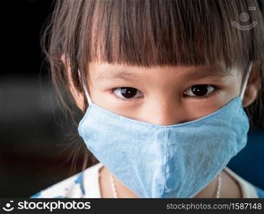 Asian child girl wearing face mask to protect her from coronavirus infection, sickness and pm2.5(Air pollution). New normal behavior.
