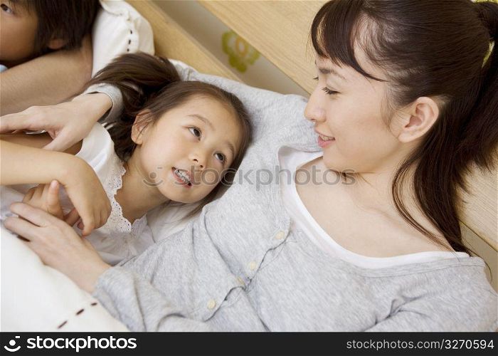 Asian child in bed with mum and dad