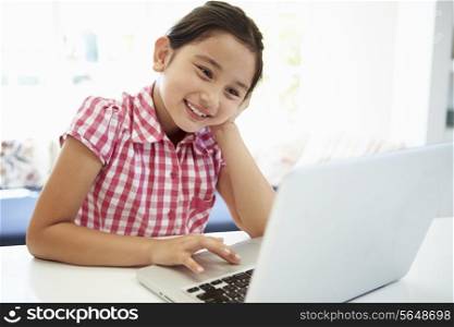 Asian Child Using Laptop At Home