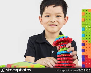 Asian children are playing puzzle plastic block creative game to practice their physical and mental skill