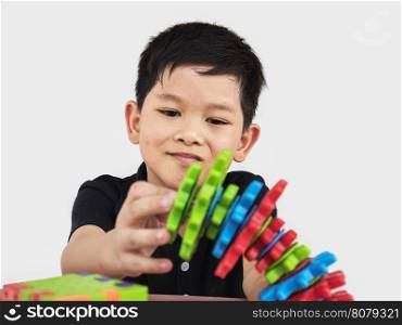 Asian children are playing puzzle plastic block creative game to practice their physical and mental skill