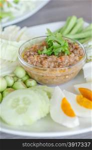 asian chili paste . Thai cuisine chili paste mixed with shrimp served with various vegetables and eggs