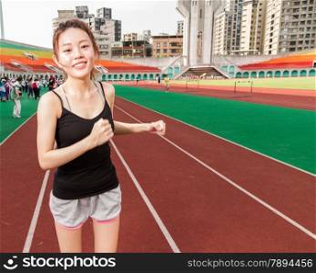 Asian Chinese woman at stadium jogging