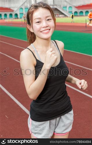 Asian Chinese woman at stadium jogging