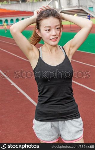 Asian Chinese woman at stadium sorts track preparing to race