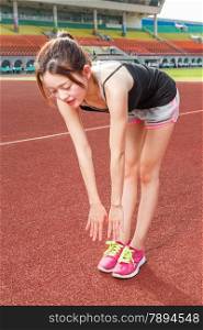 Asian Chinese woman stretching before exercise on track at stadium