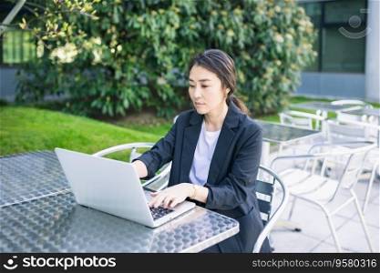 Asian confident business woman working with laptop outdoor, focused. Job, work concept. Business people lifestyle, copy space. Asian confident business woman working with laptop outdoor, focused