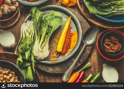 Asian cooking and eating with with healthy vegetarian ingredients on wooden background, top view