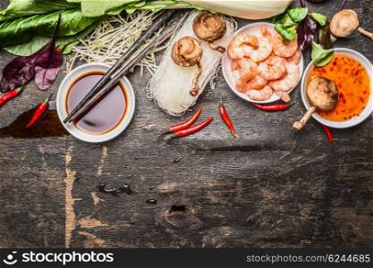Asian cooking ingredients with soy and sweet-sour sauce and chopsticks on rustic background, top view. Asian food concept.
