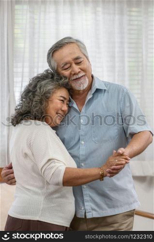 Asian couple Grandparent dancing and hugging together with happy feeling in house, romantic and lover with valentine or anniversary, Long live and Elderly society, Warm family and happiness concept